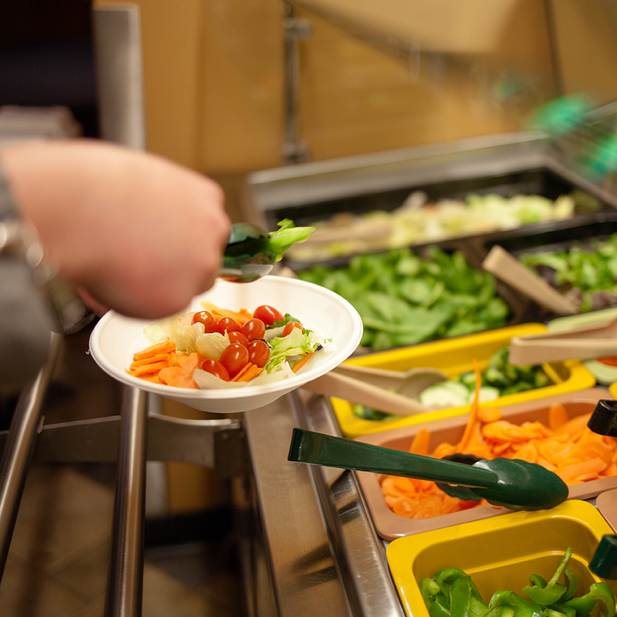 Veggies being put in a bowl. 